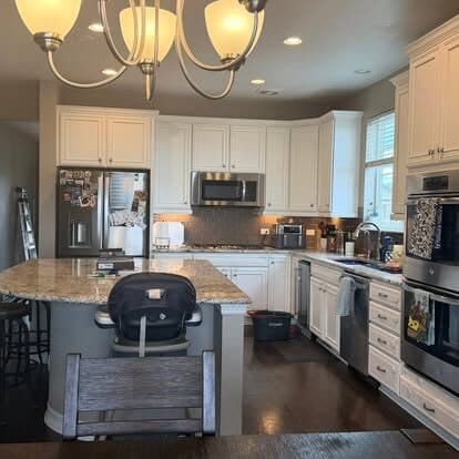 Bright white kitchen with a granite island, cleaned and tidied
